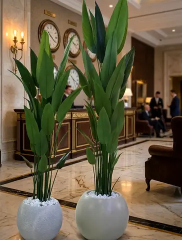 Pair of tall artificial potted plants with white pebble base