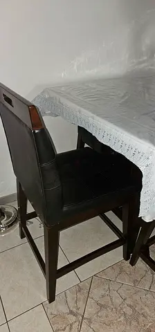 Dark wood bar stool with padded black seat and backrest - good condition