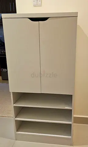 Compact white storage cabinet with shelves and doors