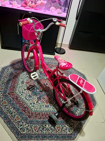 Pink girls' bicycle with training wheels and basket - good used condition