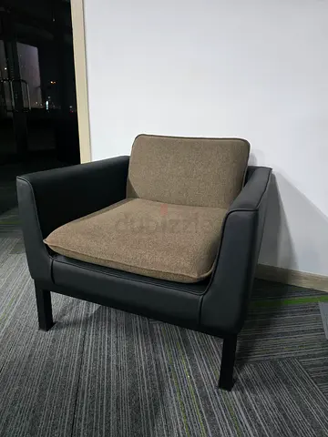 Compact single-seater armchair with black frame and beige cushions