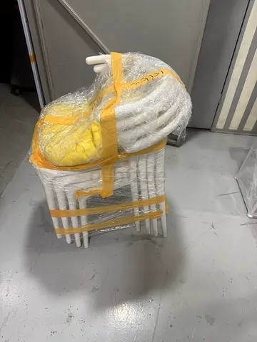 Set of 4 white dining chairs - good condition, stacked and wrapped