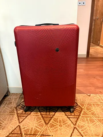 Extra large XL red hard-shell spinner suitcase with 4 wheels, I live in Al Barsha
