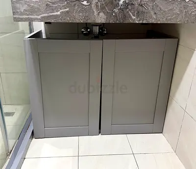 IKEA Gray bathroom vanity cabinet with double doors — compact under-sink storage