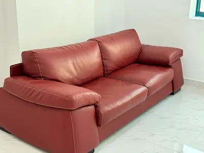 Three-seater maroon leather sofa in good condition