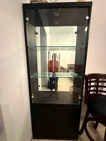 Tall black glass display cabinet with storage base - good condition