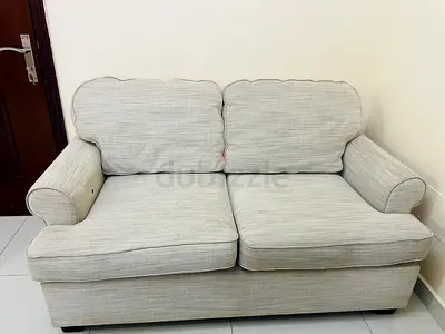Comfortable 2-seater fabric sofa with a solid wooden coffee table for sale.