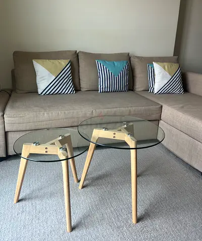 Pair of modern glass-top side tables with wooden tripod bases