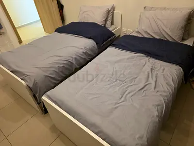Pair of single white wooden beds with brand new mattresses.