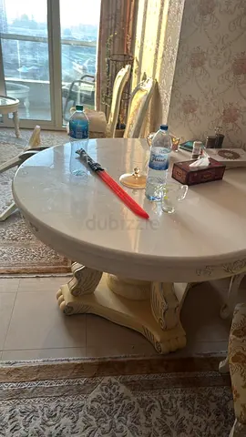 Round cream marble-top dining/coffee table with carved pedestal base