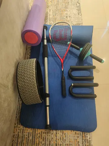 Home workout set: yoga mat, foam roller, ab wheel, resistance bar and racket