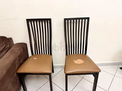 Pair of wooden dining chairs with brown faux leather seats - used