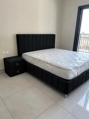 Black upholstered double bed with mattress