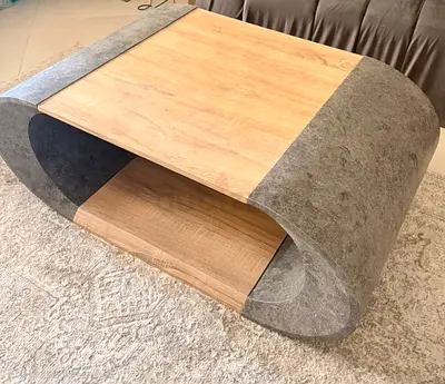 Modern curved coffee table with wood finish and stone-look sides
