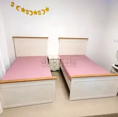 Pair of white wooden single beds with bedside table - good condition