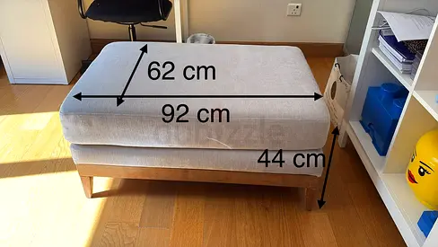 Light grey upholstered ottoman/footstool on wooden legs - 92x62x44 cm