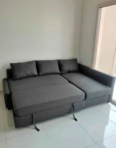 Grey L-shaped sofa bed with storage — good condition