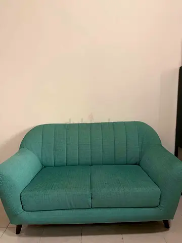Green 2-seater fabric sofa in good condition
