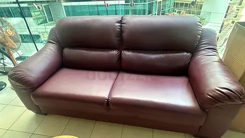 Cherry colored faux leather 3-seater sofa in good condition