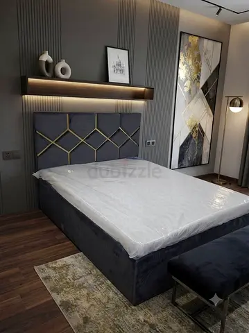 Grey upholstered double bed with headboard and mattress