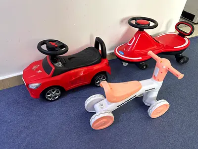 Lot of 3 ride-on toys for toddlers — red car, red glider, white-pink balance bike (all for 130)