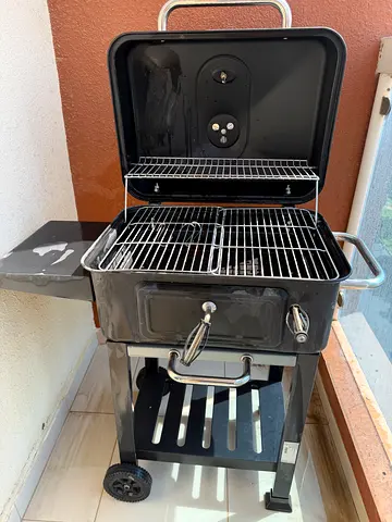 charcoal BBQ grill with wheels and side shelf