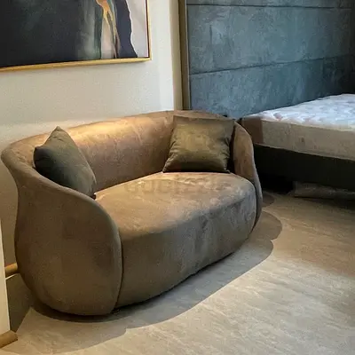 Compact 2-seater curved sofa in green fabric