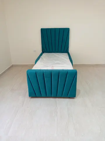 Single teal upholstered bed with headboard and footboard