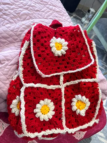 Handmade red crochet backpack with daisy motif