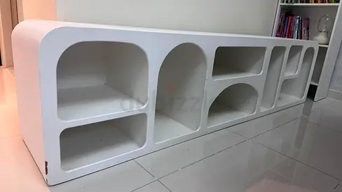 Low white modular entertainment/storage unit with rounded cubbies