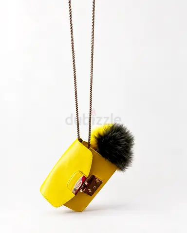 Small yellow crossbody handbag with fur pompom and chain strap