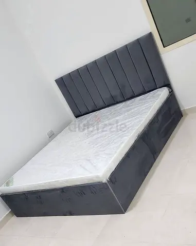 Grey upholstered double bed with storage base and headboard