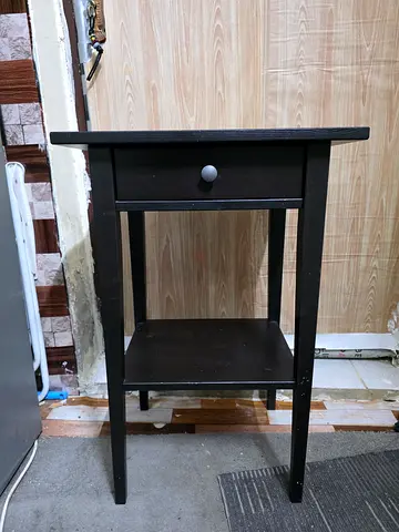 Small black wooden side table with drawer
