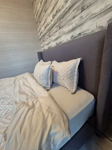 Grey fabric upholstered king sized bed frame with winged headboard and mattress - good condition