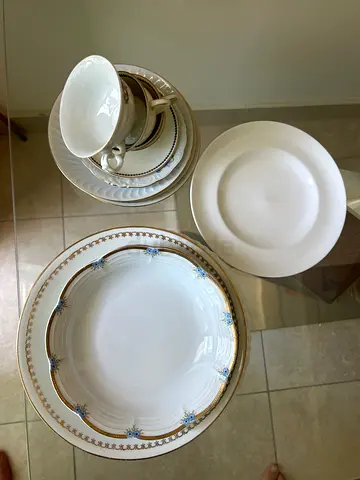 Set of vintage porcelain dinner plates and teacups bought in France
