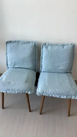 Pair of light blue upholstered dining chairs with wooden legs