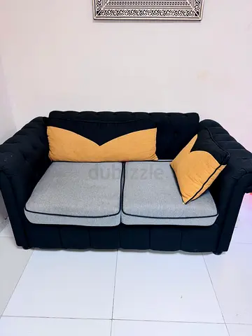 2-seater Chesterfield-style Sofa in Black with Grey Cushions and Yellow Pillows