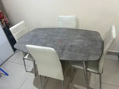 4-seater dining table with faux concrete top and white chairs