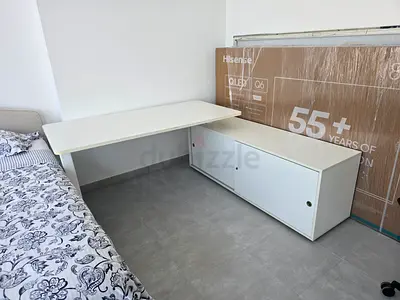 L-shaped white office desk with storage cabinet