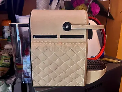 Compact capsule coffee machine in white faux-leather finish