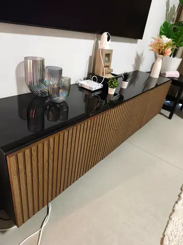 Modern Wall-Mounted TV Console with Wood Slatted Doors and Black Glass Top