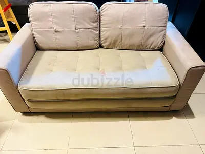 2-seater beige fabric sofa cum bed in good used condition