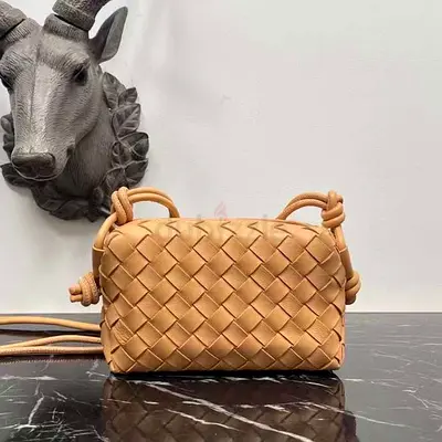 Small tan woven leather crossbody bag with knot strap