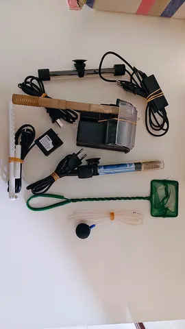 Assorted aquarium accessories — heater, filter, nets, air stone, tubing