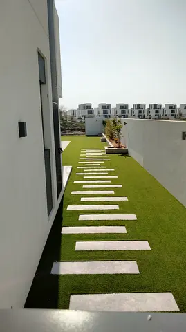 Villa side garden with artificial grass and stepping stones