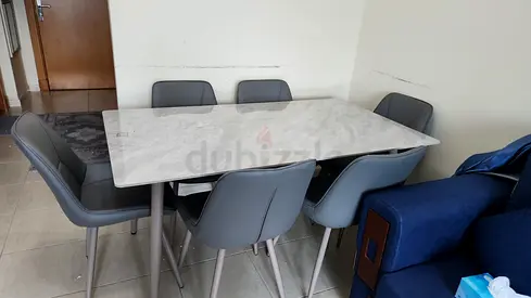 6-seater modern dining table with faux marble top and grey chairs