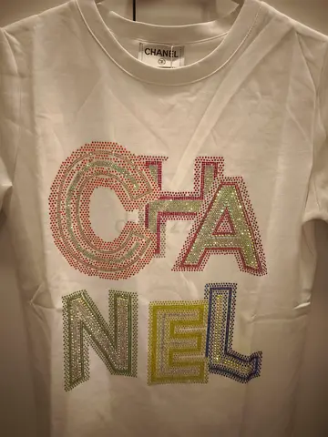 White Chanel rhinestone logo T‑shirt, multicolor crystal letters, size tag appears