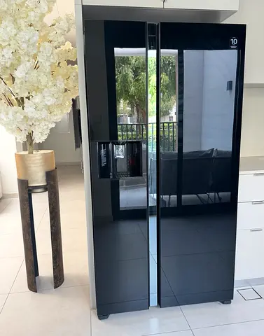 Black Side-by-Side Refrigerator - Glass Finish, Good Condition     American-style fridge with water