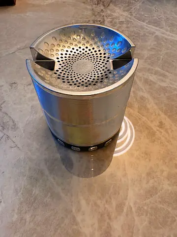 Silver color speaker with inbuilt phone stand