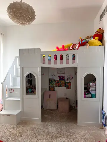 White wooden kids loft bed with built-in stairs and playhouse space with mattress